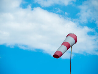 striped windsock at the airport on the background of beautiful clouds