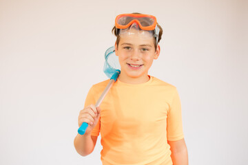 Boy in orange t-shirt preparing to dive over white background.