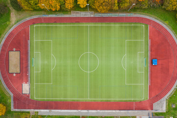 Look straight down at an empty soccer field next to a cinder track