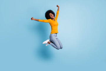 Photo portrait full body of excited girl celebrating jumping up isolated on pastel blue colored...