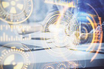 Technology theme hologram with man working on computer on background. High tech concept. Double exposure.