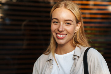 Close up of a smiling young woman walking