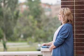 portrait of a white woman girl with blonde hair stands in a city Park and looks into the distance