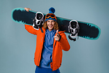 Handsome happy sportsman holding snowboard isolated