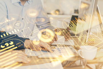 Technology theme hologram with man working on computer on background. High tech concept. Multi exposure.