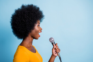 Photo side profile portrait of pretty black skinned girl singing on microphone looking at copyspace...