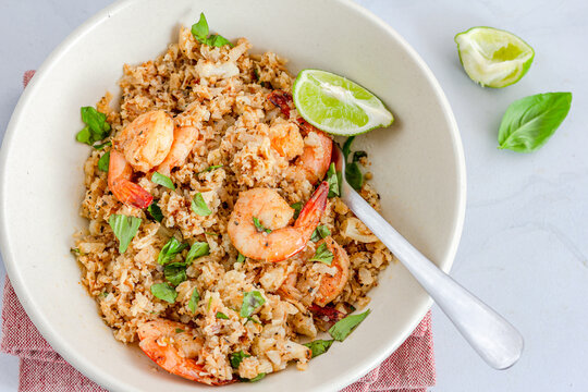 Shrimp And Cauliflower Fried Rice With Lemon And Basil Leaves Close Up Top Down Photo