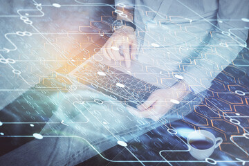 Multi exposure of data internet theme hologram with man working on computer on background. Concept of innovation.