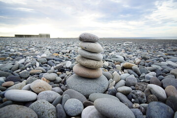 Fototapeta na wymiar Stacked round stones. A small round stone beach.
