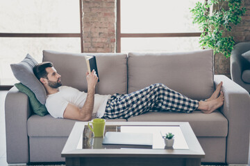 Profile side view portrait of his he nice attractive calm peaceful brunet guy lying on divan...