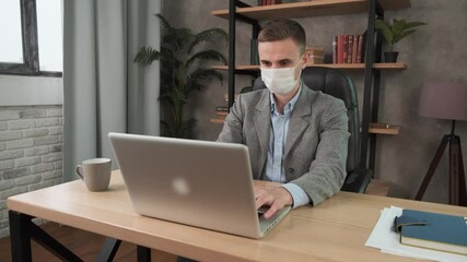 Confident young man in face mask office workplace. Remote chatting colleague internet online meeting conference webinar. Distance work webcam. Work during self-isolation and quarantine COVID-19 4k - Powered by Adobe
