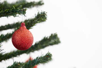 red baubles hanging from a decorated Christmas tree