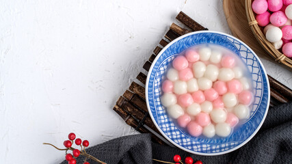 Top view of red and white tangyuan in blue bowl on white background for Winter solstice.