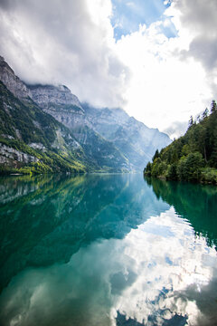 Clear blue summer day at lake Klontalersee. Glarnisch, mountain range reflecting in the water. Landscape in Switzerland.
