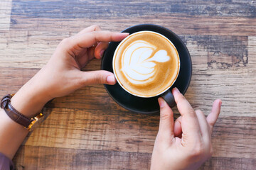 top view of women hand holding a coffee cup 