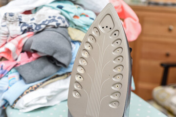 House work and chores at home Steam iron with a pile of clothes to be ironed