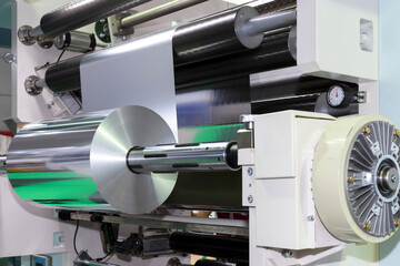roll of aluminum foil for food packaging on automatic packing machine in food product factory....