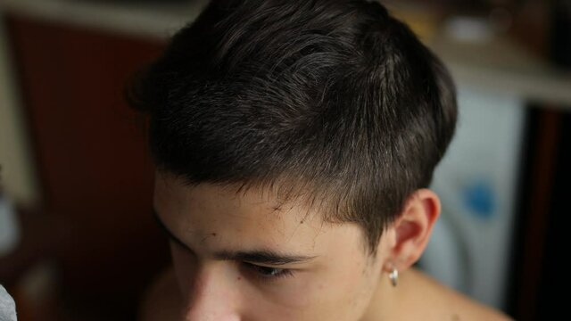 men's haircut with a clipper at home. men's haircut in quarantine. haircut in quarantine. a master cuts a young European-looking guy with a clipper. men's haircut with clipper close-up