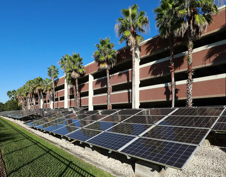 Solar panels installed in front of a parking garage converting the sun's rays into electricity.