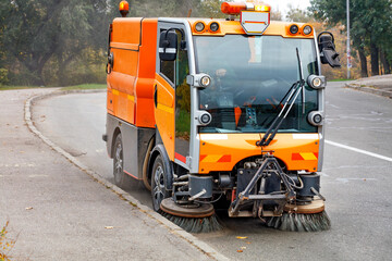 A hydraulically powered road sweeper sweeps the street. - 388759044