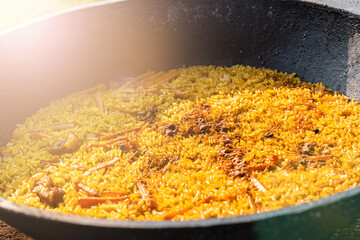 Freshly cooked pilaf in a big metal cauldron.