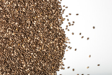 Chia seeds on white and grey gradient background. Place for text, top view, macro photography.