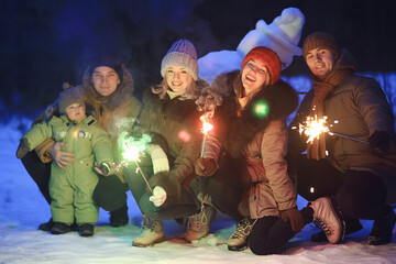 group of friends with snowman sparklers party, christmas night and happy new year