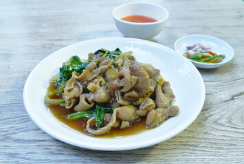 braised pork innards in black Chinese herb soup on plate dipping spicy sauce eat couple fresh chili and garlic
