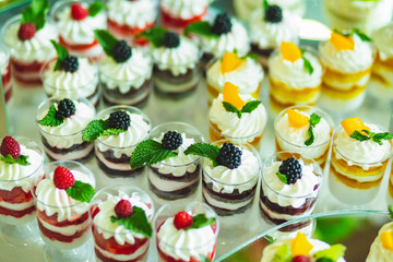 Candy bar. Delicious holiday reception on dessert table. Festive table with a variety of sweets, cakes, candies, desserts, tartlets and cupcakes. Sweet table with desserts for the holidays
