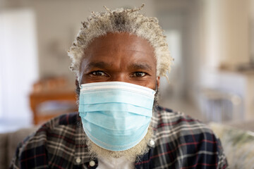 Portrait of senior man wearing face mask at home