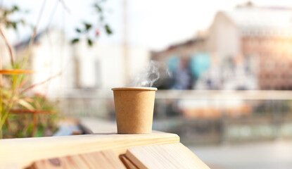 Paper cup with hot coffee in urban area.
Pappbecher mit heißem Kaffee in urbaner Gegend.