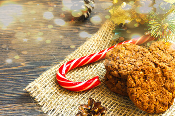 Christmas card, food photo. Cookies with a caramel stick on the new year's table. Design, composition of spruce branches and glitter confetti, bokeh. Template, blank for a poster, greeting cards, head