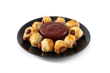 Pigs in blankets. Mini sausages wrapped in puff pastry with ketchup sauce isolated on white background