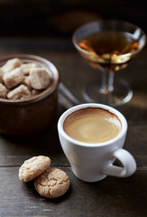 Cup of coffee with amaretti (Italian biscuits) on rustic wooden background. Close up. 