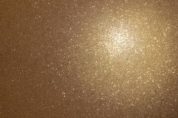 Gold background with texture and sparkling stars in a spot of light (Macro focus on texture)