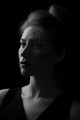 Black-and-white studio portrait of a beautiful and serious young woman.