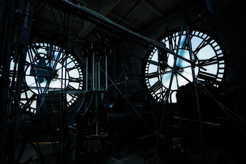 Interior of old big tower clock face mechanism inside brick space with two sides of the building