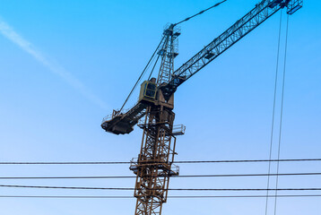 Tower crane against the blue sky, close-up.