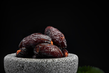 Bowl of dried dates on dark wooden background