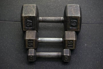 Dumbbells of different denominations lying on the floor. The concept of developing and increasing strength.
