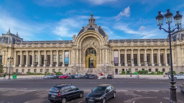 The exterior including the dome of the Petit Palais museum timelapse hyperlapse in Paris France. View from Grand Palais with traffic on road. Blue cloudy sky at summer day