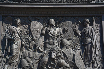 Fototapeta na wymiar The pedestal of the Alexander Column is decorated with symbols of military glory, sculpted by Giovanni Battista Scotti, in St.Petersburg, Russia
