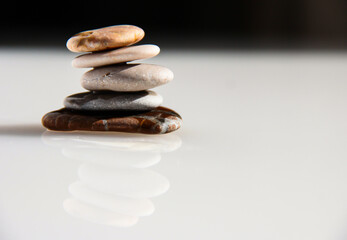Sea pebbles on a blurry background. The stones are laid out in the form of a pyramid.