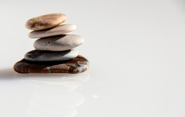 Sea pebbles on a blurry background. The stones are laid out in the form of a pyramid.
