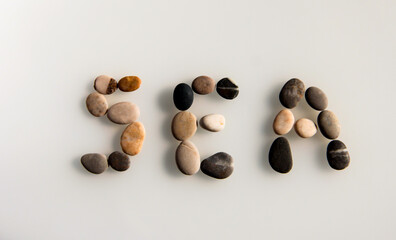 The word sea is laid out of sea stones on a light background.