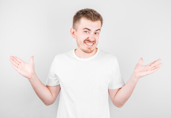 Shrugging man in white t-shirt looking at camera