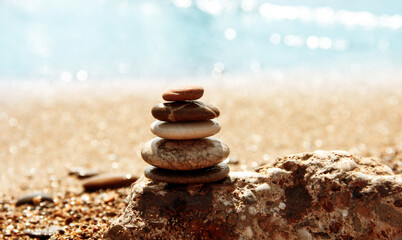 Sea pebbles on the background of the azure sea coast. Sea background. Relax. Pyramid