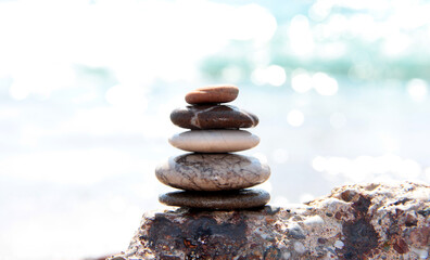 Sea pebbles on the background of the azure sea coast. Sea background. Relax. Pyramid