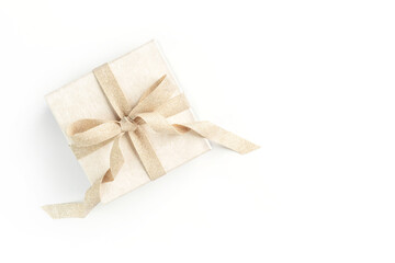 Beautiful present box with elegant golden bow on isolated white background. Festive backdrop for your holiday design. Flat lay style.