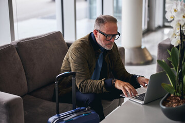 Serious bearded man using his computer indoors